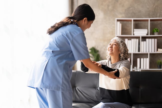 female medical assistant comforting older female patient