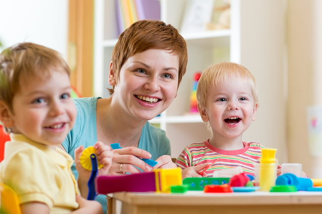 Preschool teacher with two young students.