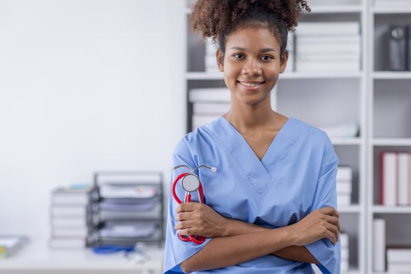 medical assistant student smiles into camera holding a stehoscope