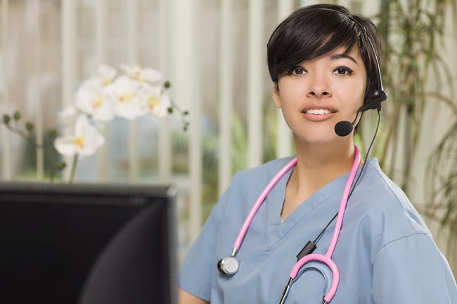 Medical assistant wearing a phone headset looking at the camera.