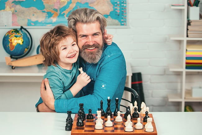 Male teacher bonding with a student through teaching him how to play chess