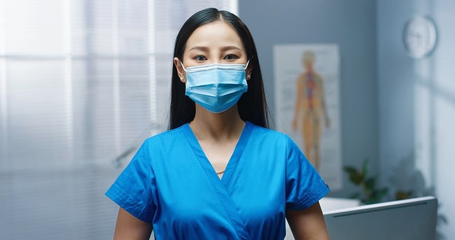 Medical assistant working in a hospital wearing a mask.