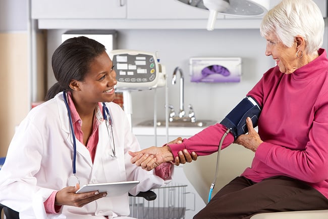 Medical assistant taking a woman's blood pressure.