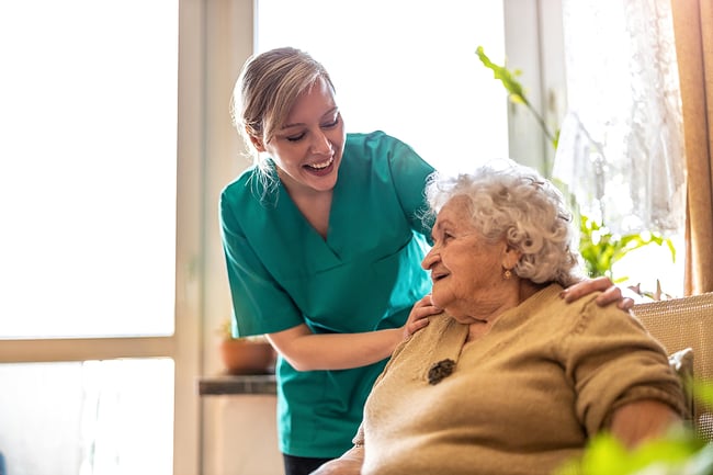 Smiling female medical assistant helping an elderly patient.