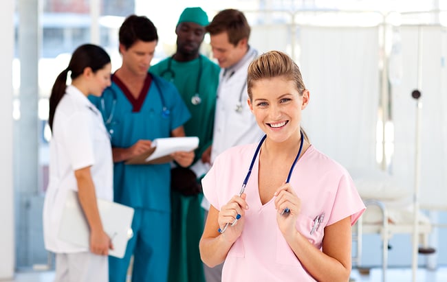 Smiling medical assistant with a group of hospital staff.