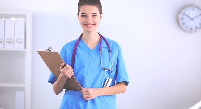 Smiling medical assistant student holding a clipboard.