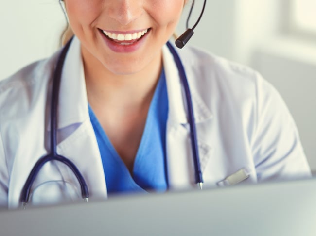 Close up of medical assistant answering the phone on a headset.